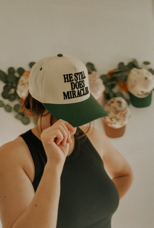 He Still Does Miracles Trucker Hat